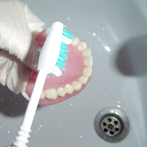 Cleaning Dentures over a sink